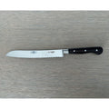 Laguiole forged bread knife with black ebony handle on a grey wood surface