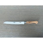 Laguiole forged bread knife with olive wood handle on a grey wood surface