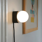 round glass globe on a handmade ceramic sconce