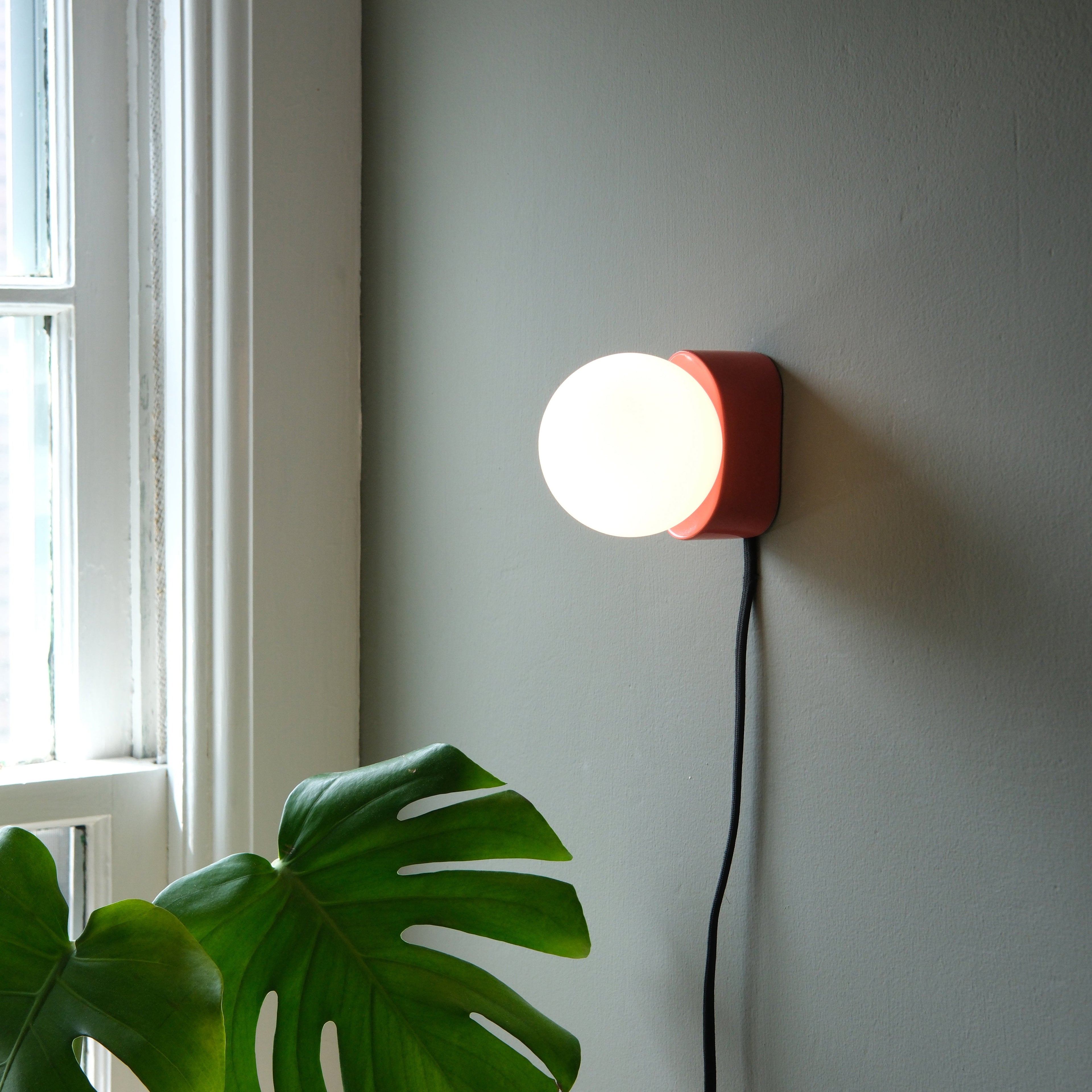 Iota Sconce in speckle glaze mounted on a wall